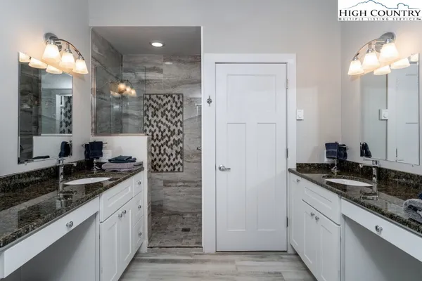 a bathroom with a granite countertop sink a large mirror and a shower