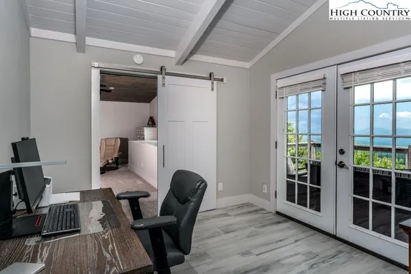 a view of a workspace with furniture and a window