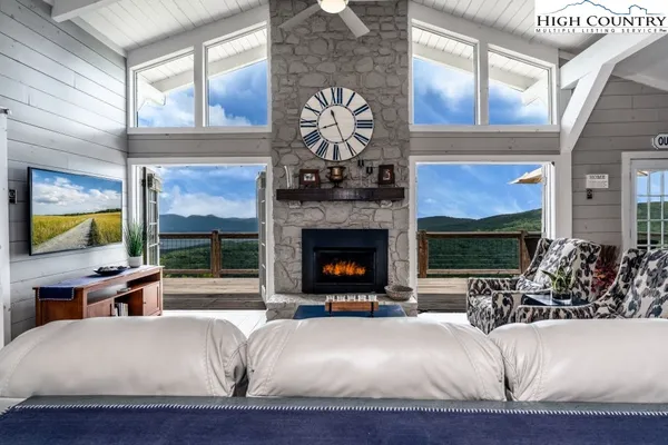 a living room with fireplace furniture and a large window