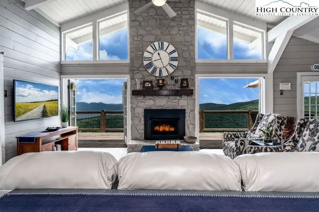 a living room with fireplace furniture and a large window