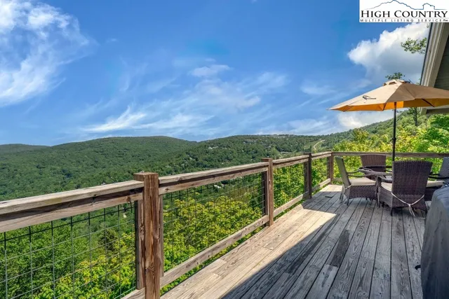 a view of a balcony with wooden floor & fence