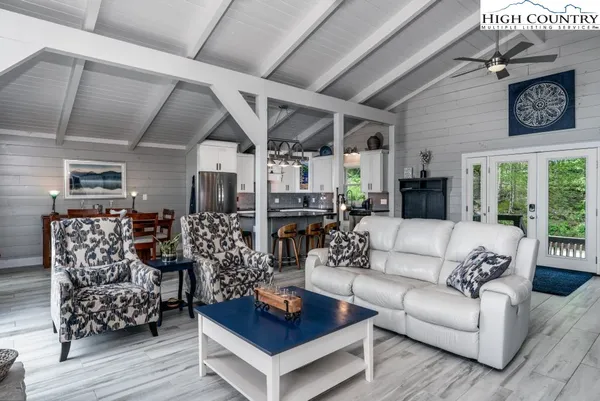 a living room with furniture kitchen view and a large window