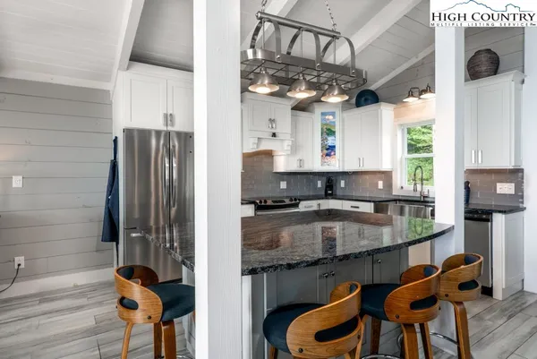 a kitchen with stainless steel appliances granite countertop a sink a stove and a wooden floors