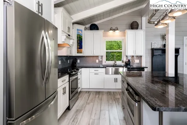 a kitchen with a refrigerator a sink and dishwasher a refrigerator with wooden floor