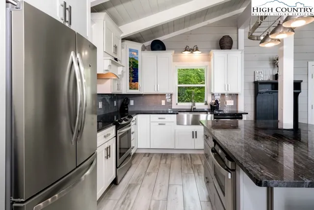 a kitchen with a refrigerator a sink and dishwasher a refrigerator with wooden floor