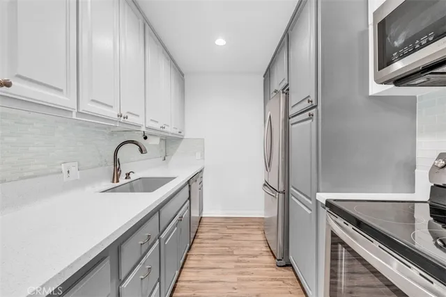 a kitchen with stainless steel appliances granite countertop a sink and cabinets