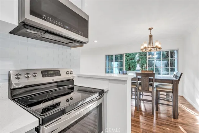 a kitchen with a stove a microwave and furniture