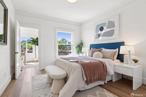 a bedroom with a large bed and a potted plant