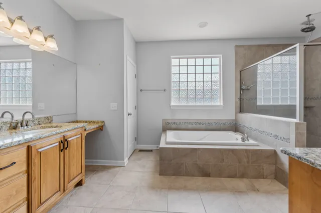 a spacious bathroom with a tub sink and mirror