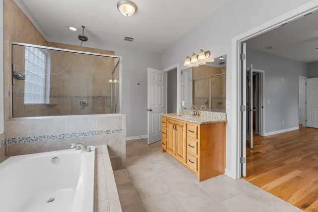 a spacious bathroom with a tub shower and sink