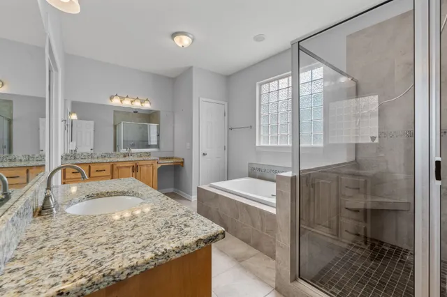 a bathroom with a granite countertop sink a mirror and shower