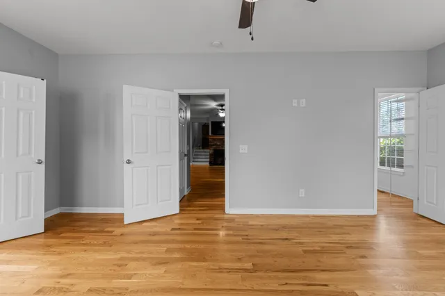 a view of empty room with wooden floor and window