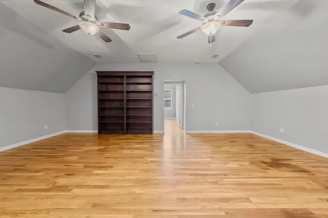 a view of an empty room with a ceiling fan and window