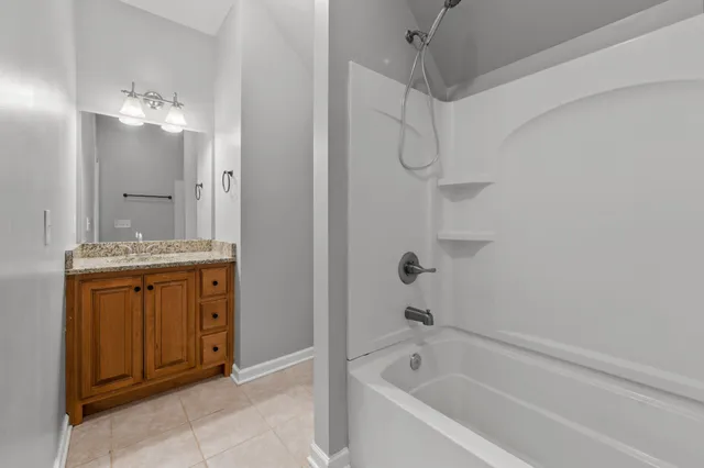 a bathroom with a granite countertop sink a mirror and a bathtub