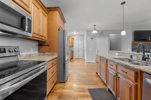 a kitchen with stainless steel appliances granite countertop a stove a sink and a microwave