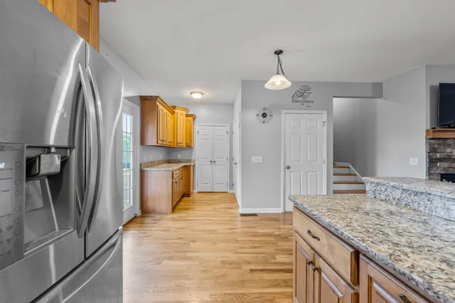 a bathroom with a granite countertop sink and a refrigerator