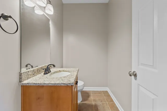 a bathroom with a granite countertop sink toilet and a mirror