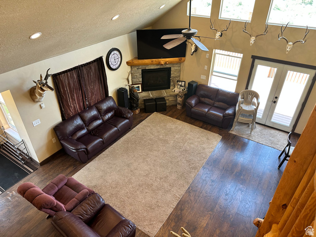 12 Crook Street Fish Haven, ID 83287 - Photo 19 of 35 Living room with ceiling fan, a stone fireplace, dark wood-type flooring, french doors, and a high textured ceiling