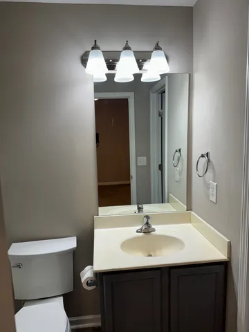 a bathroom with a toilet a sink and mirror