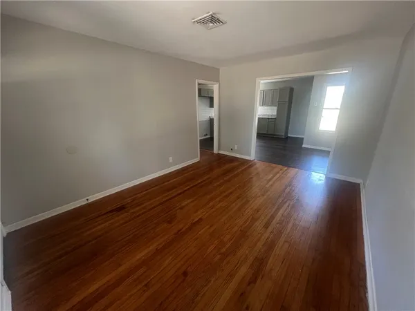 a view of empty room with wooden floor