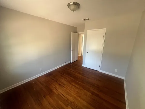 a view of an empty room with wooden floor