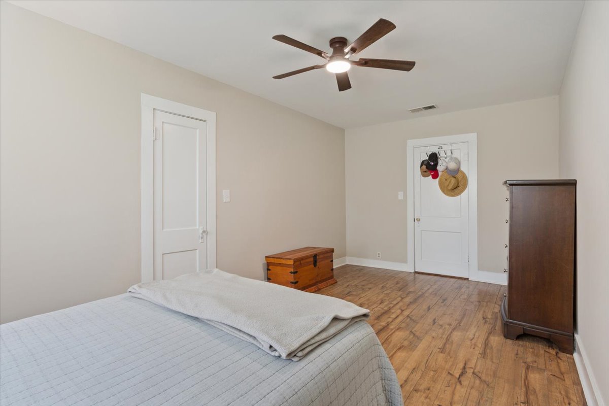 1607 North Harding Avenue Cameron, TX 76520 - Photo 25 of 37 Rich hardwood floors complement the neutral walls in this well-lit bedroom.