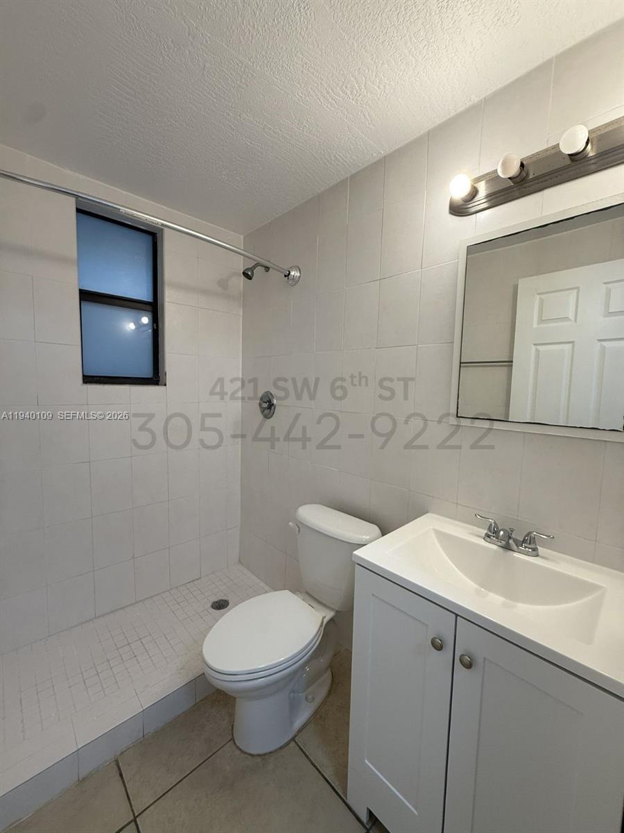 421 Southwest 6th Street, Unit 9 Miami, FL 33130 - Photo 8 of 9 a bathroom with a toilet a sink a mirror and vanity