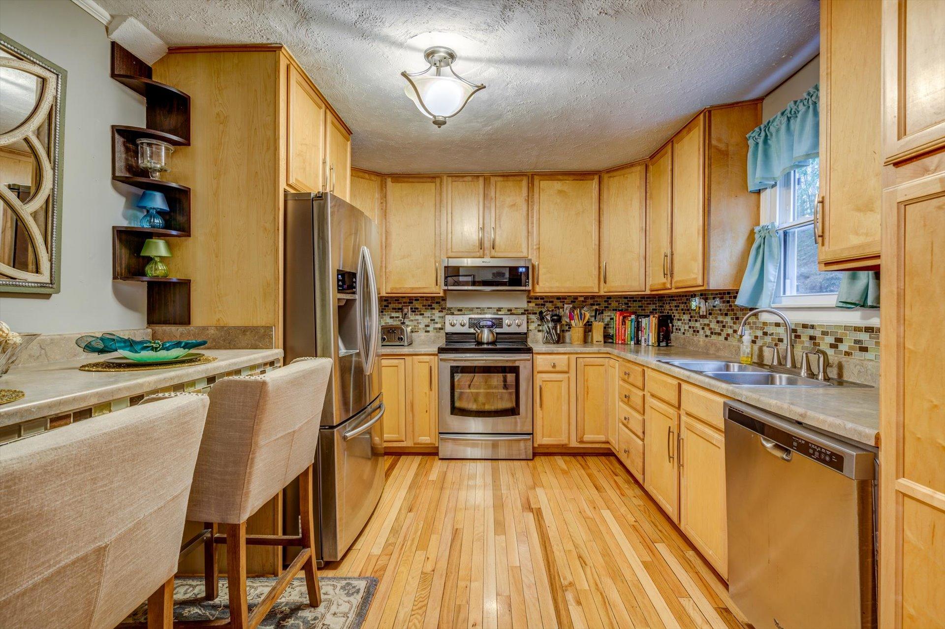 772 Skyview Road Salem, VA 24153 - Photo 11 of 41 a kitchen with granite countertop wooden floors stainless steel appliances and sink