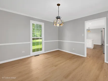 a view of empty room with wooden floor and window