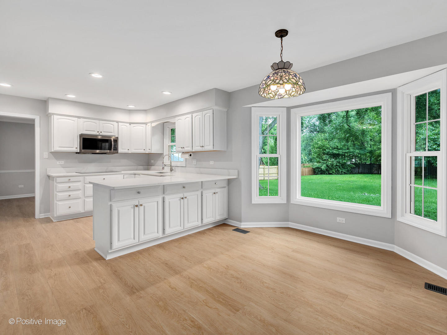 805 Potomac Avenue Naperville, IL 60565 - Photo 8 of 38 a large white kitchen with granite countertop a stove a sink dishwasher and white cabinets with wooden floor