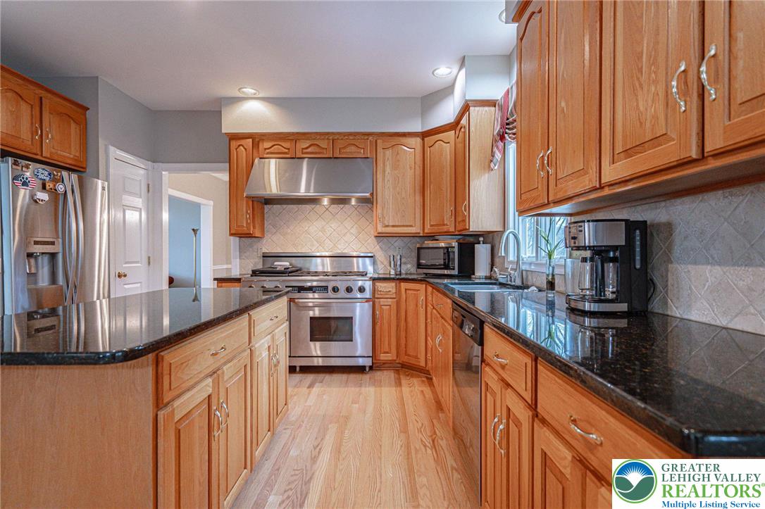 6551 Overlook Road Orefield, PA 18069 - Photo 22 of 82 a kitchen with stainless steel appliances granite countertop a stove a sink and a refrigerator