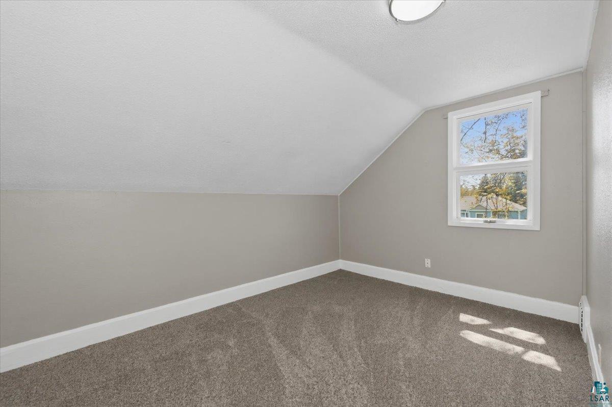 5319 East 3rd Street Superior, WI 54880 - Photo 28 of 33 Carpeted room featuring a white-framed window, sloped ceiling, and neutral-toned walls with white trim