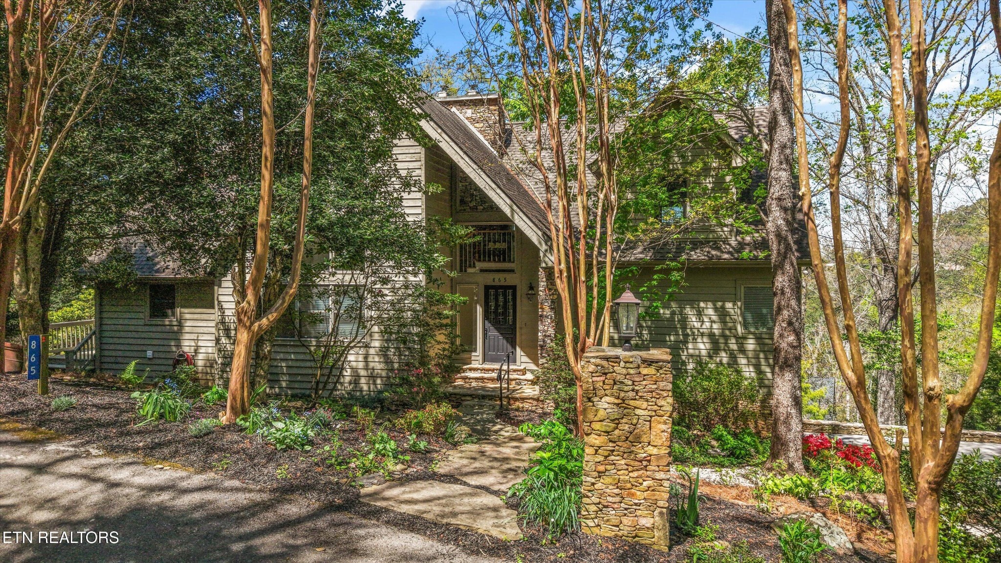 a front view of a house with a tree