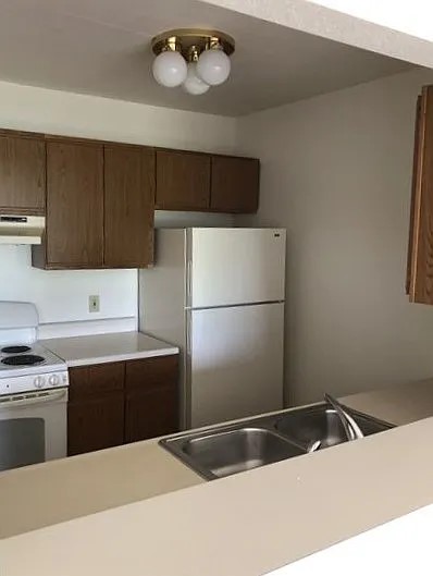 306 Knight Street Grayling, MI 49738 - Photo 2 of 4 a kitchen with a sink a stove and refrigerator