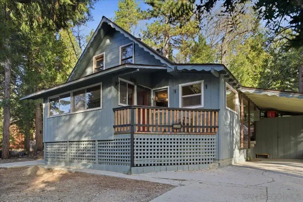 a front view of a house with a tree