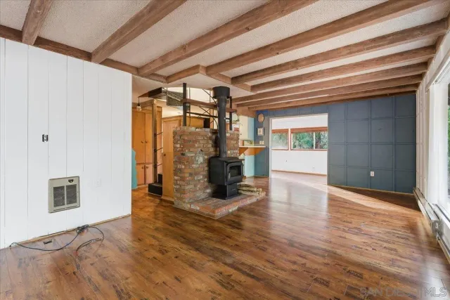 a view of a livingroom with wooden floor and furniture