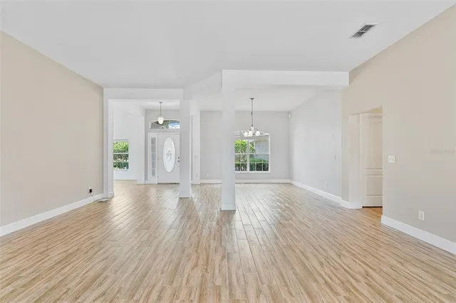 a view of empty room with wooden floor and window