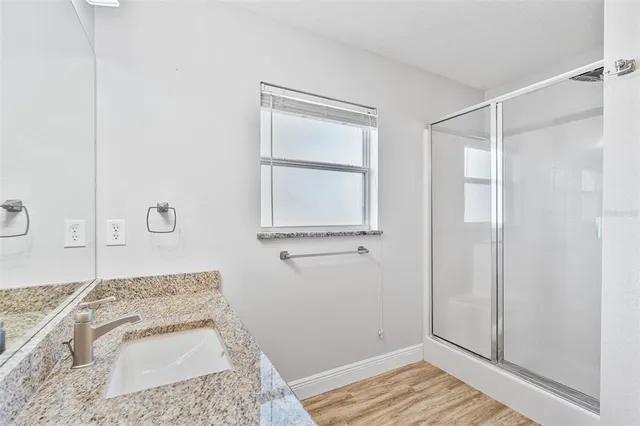 a bathroom with a granite countertop tub sink and mirror