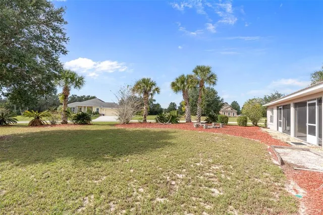 a view of a yard in front of a house with large tree