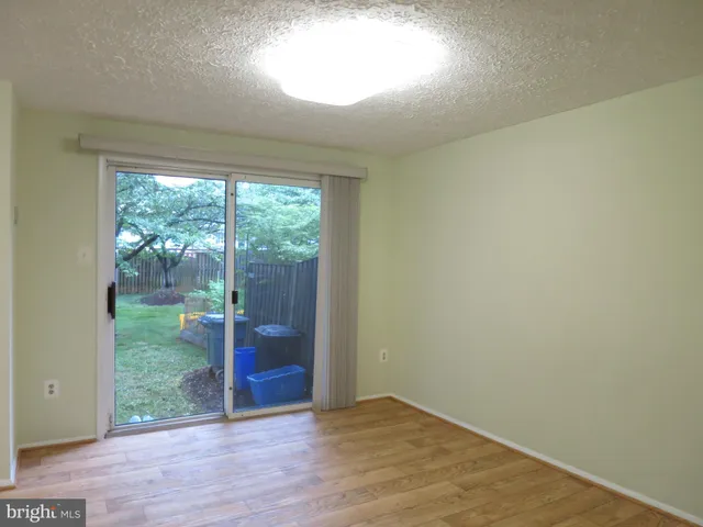 an empty room with wooden floor and outdoor view