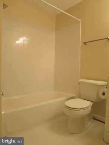 a white toilet sitting next to a bath tub
