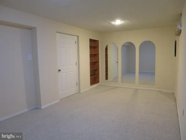 a view of an empty room with closet and entryway