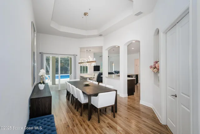 a kitchen with stainless steel appliances kitchen island granite countertop a refrigerator a stove and a wooden floors