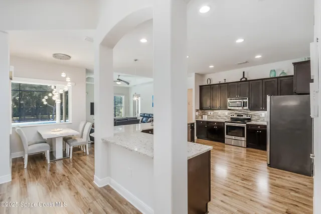 a kitchen with kitchen island granite countertop a refrigerator stove top oven and sink