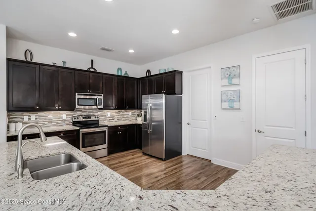 a kitchen with stainless steel appliances kitchen island granite countertop a sink and cabinets