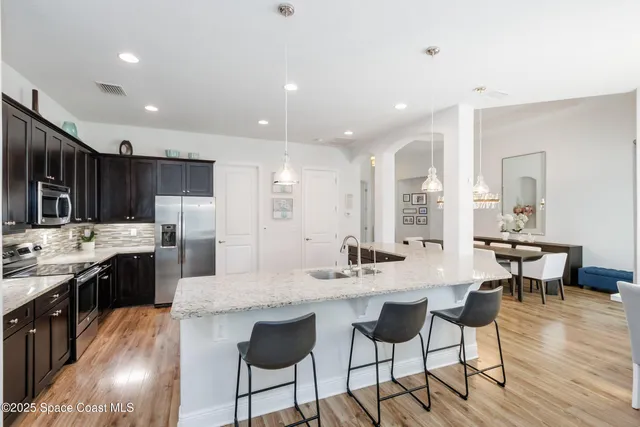 a kitchen with kitchen island granite countertop stainless steel appliances and sink