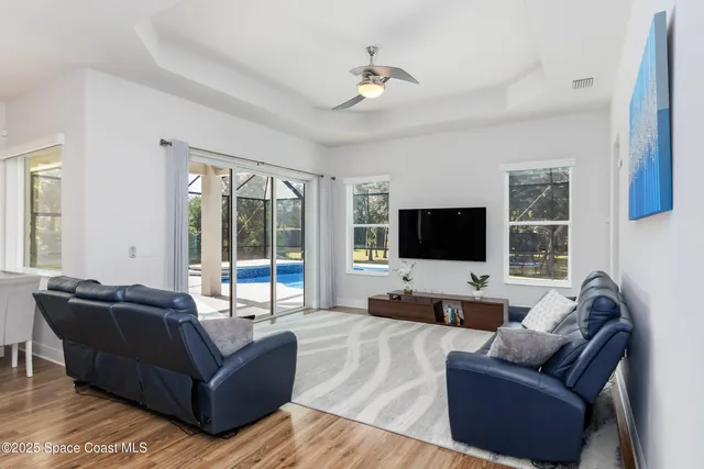 a large living room with a couches and kitchen view