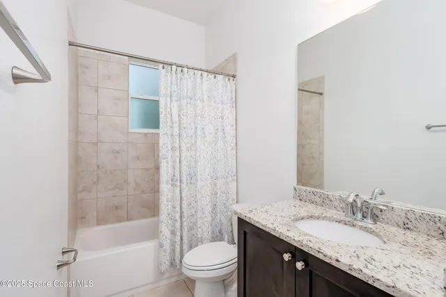 a bedroom with a bed and a flat tv screen on dresser