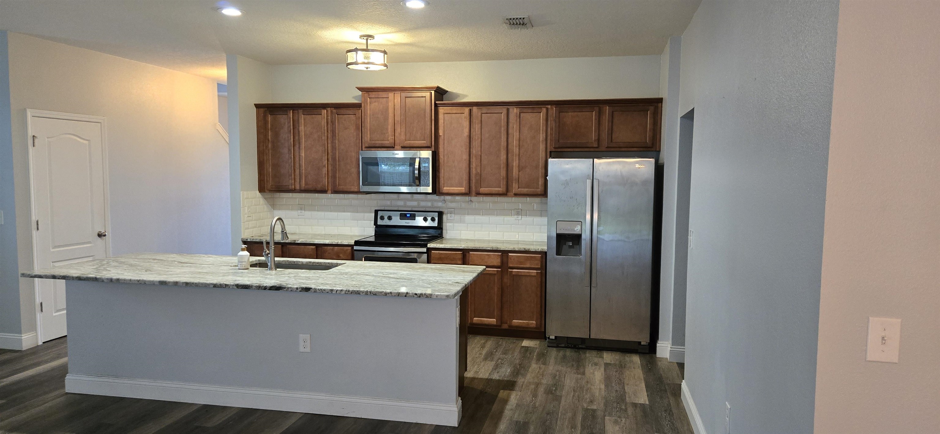 194 Ashby Lndg Way St. Augustine, FL 32086 - Photo 3 of 12 a kitchen with kitchen island granite countertop a sink stove and refrigerator