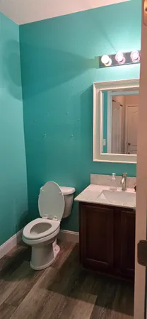 a bathroom with a toilet a sink and mirror